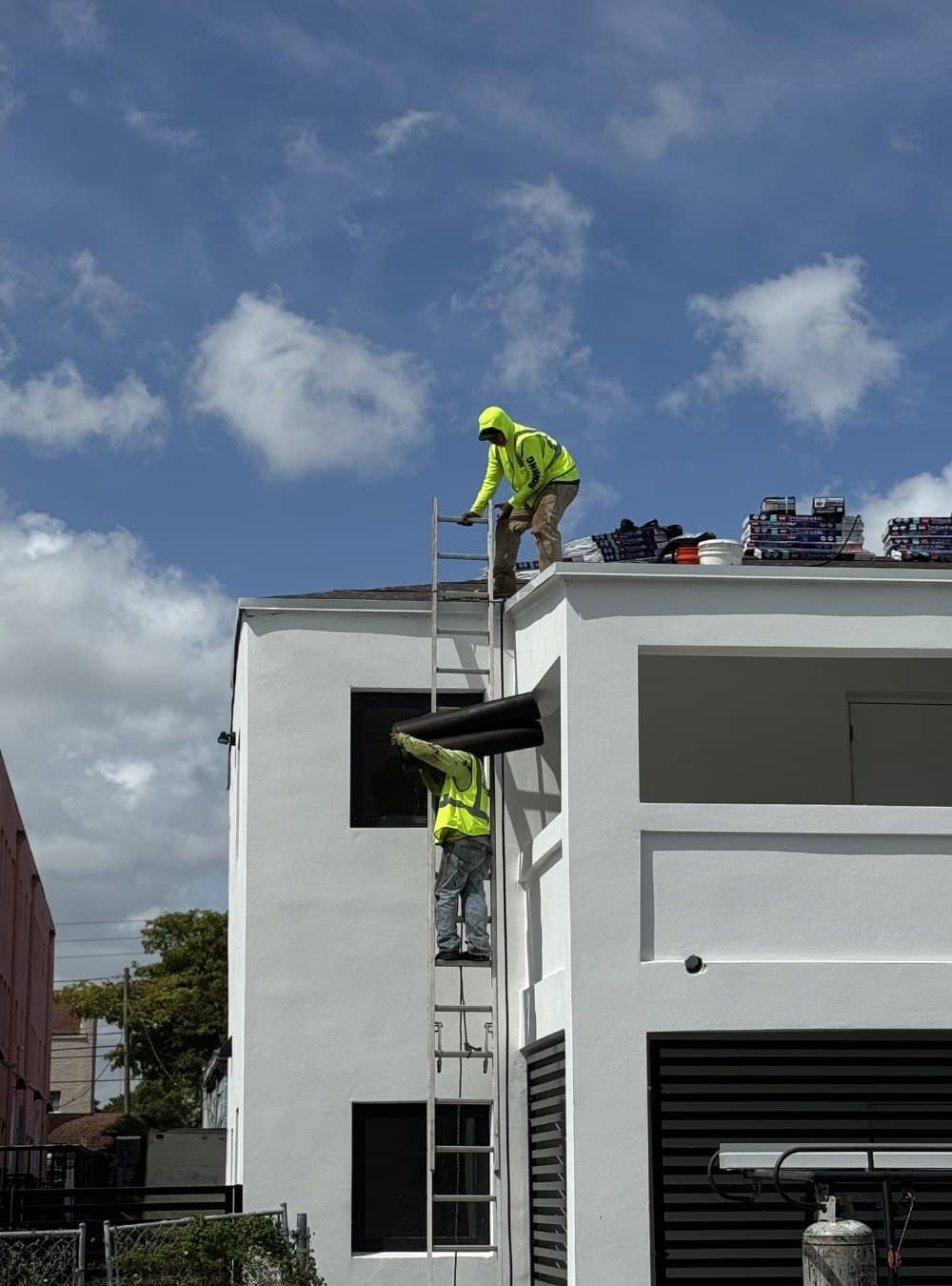 Novara crew on the roof of a three-story building during a roof coating job in Palm Beach