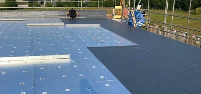 Flat roof membrane being installed on a commercial building