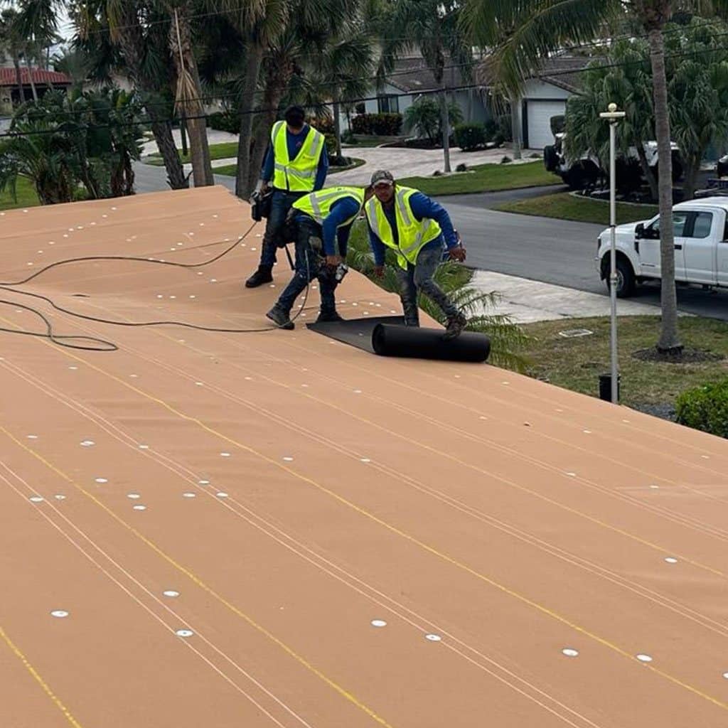 Crew rolling out membrane on a flat roof